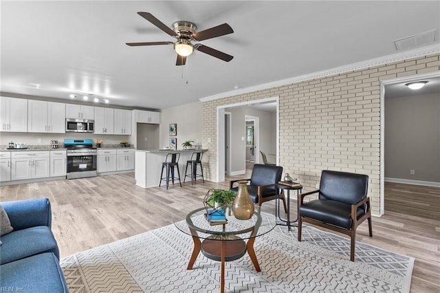 1309 Wickham Ave, Newport News, VA 23607 - living room with light wood-type flooring, brick wall, a ceiling fan, and ornamental molding