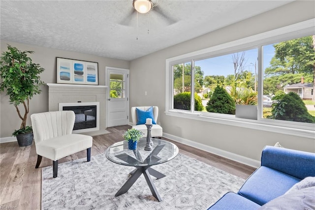 1309 Wickham Ave, Newport News, VA 23607 - living area with a fireplace with flush hearth, a textured ceiling, wood finished floors, and ceiling fan