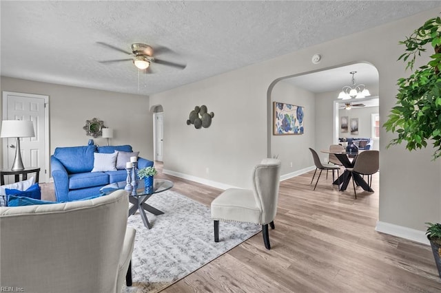 1309 Wickham Ave, Newport News, VA 23607 - living room featuring arched walkways, light wood-style floors, ceiling fan, a chandelier, and a textured ceiling