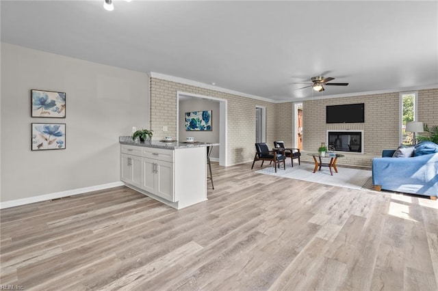 1309 Wickham Ave, Newport News, VA 23607 - living area with light wood finished floors, brick wall, a ceiling fan, a fireplace, and ornamental molding
