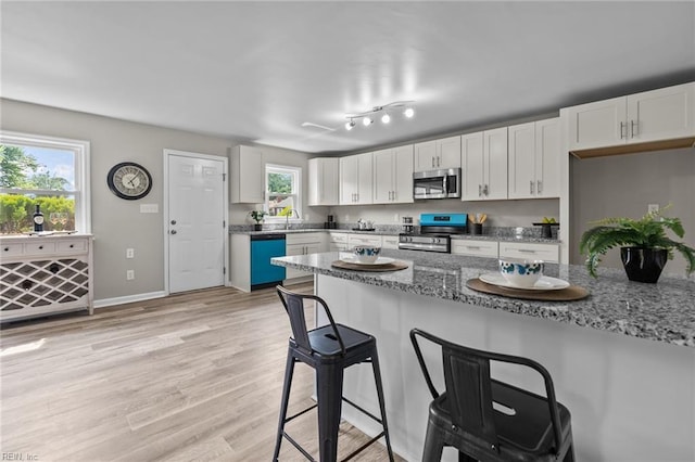 1309 Wickham Ave, Newport News, VA 23607 - kitchen featuring stainless steel appliances, a breakfast bar, white cabinets, light wood-style floors, and stone countertops