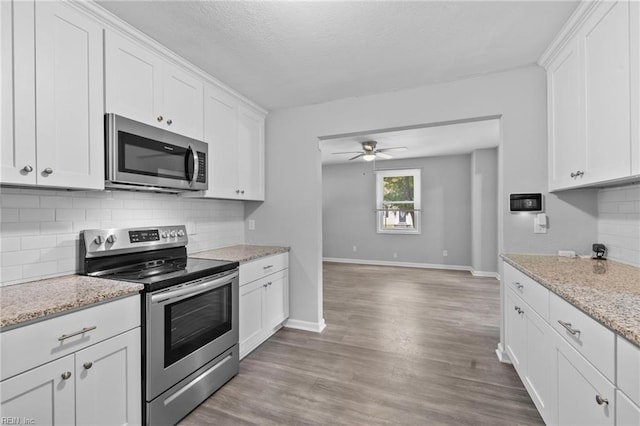 4825 Robin Hood Rd, Norfolk, VA 23513 - kitchen featuring stainless steel appliances, a ceiling fan, white cabinets, light wood-type flooring, and a textured ceiling