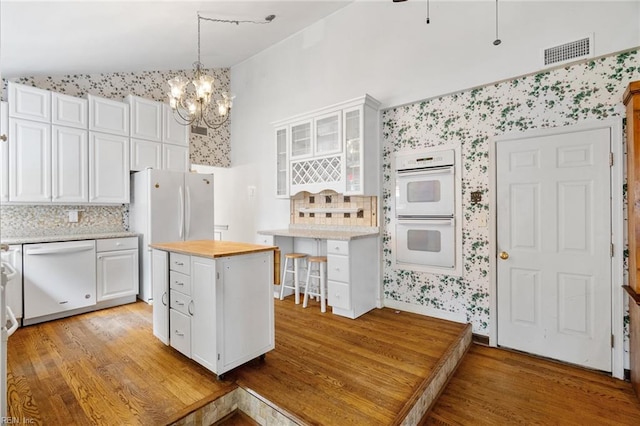 318 Hearthstone Way, Newport News, VA 23608 - kitchen featuring white appliances, vaulted ceiling, white cabinets, light wood finished floors, and decorative backsplash
