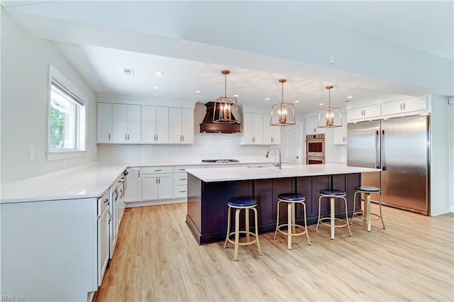 5227 Lake Shores Rd, Virginia Beach, VA 23455 - kitchen with stainless steel appliances, custom exhaust hood, light wood finished floors, decorative backsplash, and a large island