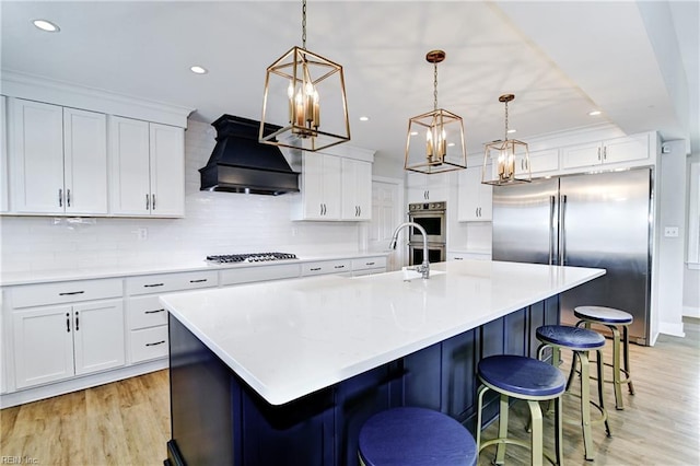 5227 Lake Shores Rd, Virginia Beach, VA 23455 - kitchen featuring premium range hood, appliances with stainless steel finishes, light wood finished floors, white cabinets, and recessed lighting