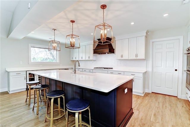 5227 Lake Shores Rd, Virginia Beach, VA 23455 - kitchen with an island with sink, light wood-type flooring, a breakfast bar, wine cooler, and light countertops