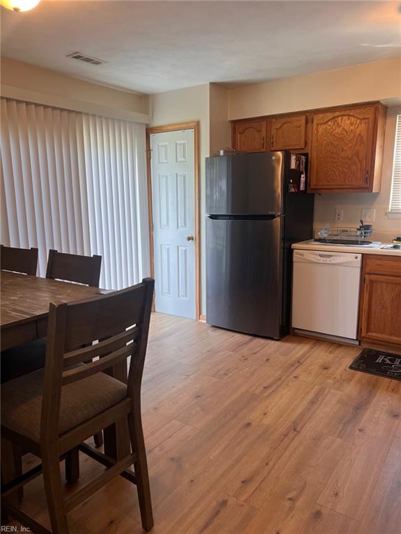 222 Greenfield Cres, Suffolk, VA 23434 - kitchen featuring dishwasher, freestanding refrigerator, brown cabinetry, light wood finished floors, and light countertops