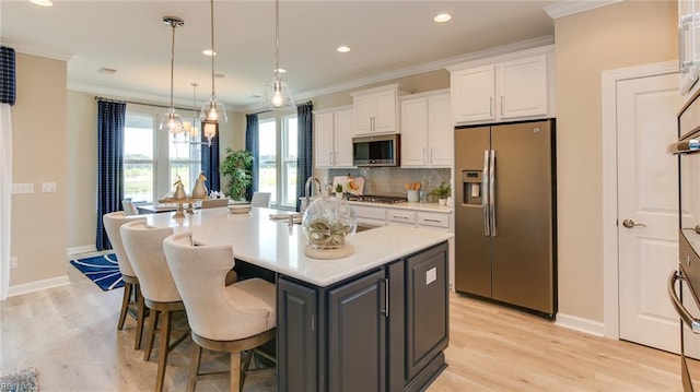 242 Quarter Horse Loop, Hertford, NC 27944 - kitchen featuring stainless steel appliances, white cabinetry, an island with sink, light wood-style floors, and crown molding