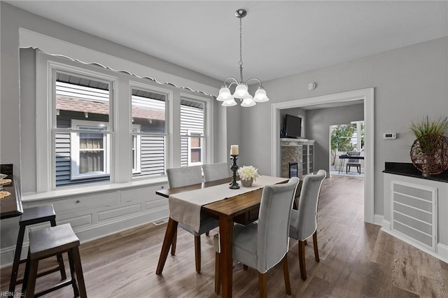 2724 Kimball Ter, Norfolk, VA 23504 - dining room featuring a chandelier, a glass covered fireplace, and wood finished floors