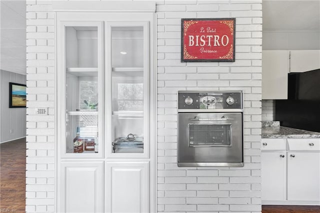 2 Sir Francis Wyatt Pl, Newport News, VA 23606 - detailed view of stainless steel oven, white cabinets, dark wood-style floors, and light stone countertops