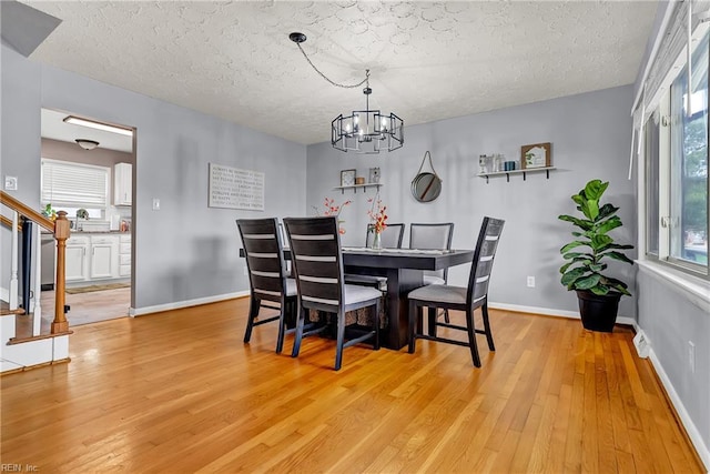 5013 Cay St, Hampton, VA 23605 - dining space with stairway, light wood-style floors, a textured ceiling, a chandelier, and plenty of natural light