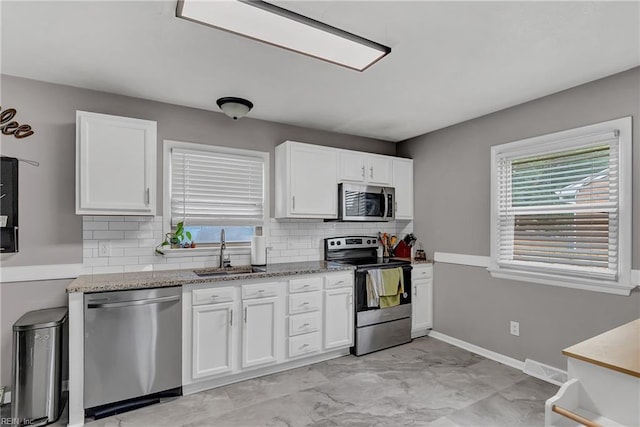 5013 Cay St, Hampton, VA 23605 - kitchen featuring stainless steel appliances, backsplash, white cabinets, light stone countertops, and light marble finish floors