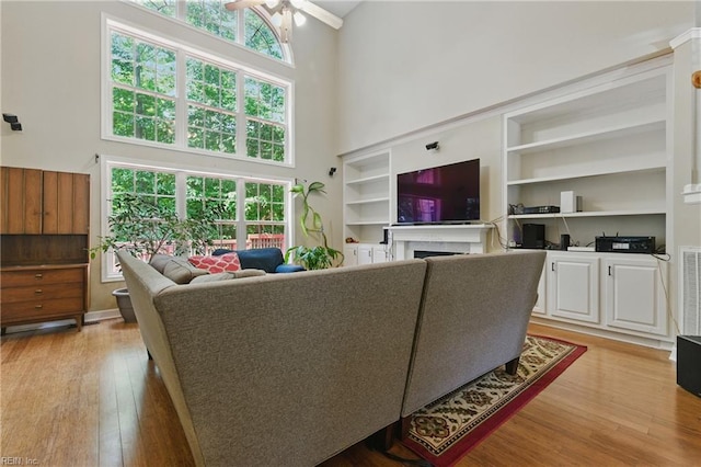 418 Rolling Hills Dr, Williamsburg, VA 23185 - living room with a high ceiling, a ceiling fan, light wood-type flooring, a fireplace, and built in features