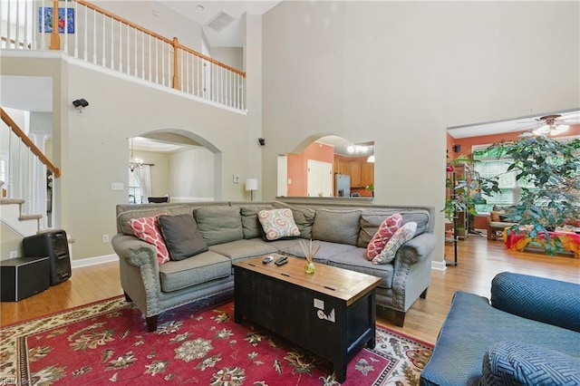 418 Rolling Hills Dr, Williamsburg, VA 23185 - living room featuring a high ceiling, wood finished floors, arched walkways, stairs, and a chandelier