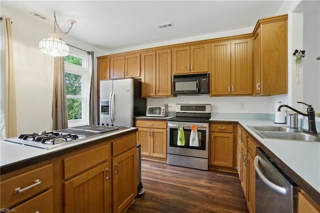 1039 Little Bay Ave, Norfolk, VA 23503 - kitchen featuring appliances with stainless steel finishes, dark wood-style flooring, hanging light fixtures, and brown cabinetry