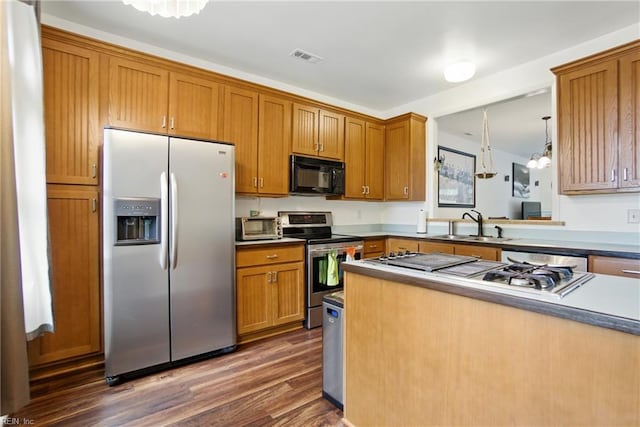 1039 Little Bay Ave, Norfolk, VA 23503 - kitchen featuring appliances with stainless steel finishes, dark wood-style floors, brown cabinetry, and pendant lighting