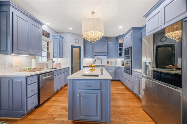 6003 Spinnaker Cove Ct, Suffolk, VA 23435 - kitchen featuring appliances with stainless steel finishes, a chandelier, a kitchen island with sink, light countertops, and tasteful backsplash
