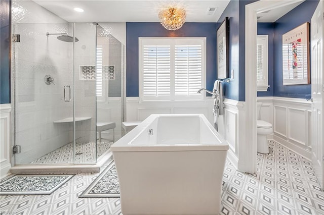 6003 Spinnaker Cove Ct, Suffolk, VA 23435 - bathroom featuring a decorative wall, a freestanding bath, plenty of natural light, a stall shower, and a wainscoted wall