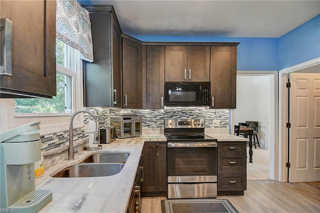 832 Doe Run Dr, Chesapeake, VA 23322 - kitchen with black microwave, stainless steel electric range oven, light wood-style flooring, and dark brown cabinets
