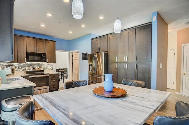 832 Doe Run Dr, Chesapeake, VA 23322 - kitchen featuring stainless steel appliances, backsplash, a breakfast bar, recessed lighting, and light stone countertops