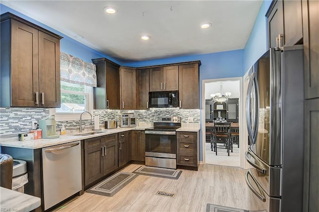 832 Doe Run Dr, Chesapeake, VA 23322 - kitchen featuring appliances with stainless steel finishes, light wood-style flooring, tasteful backsplash, dark brown cabinets, and recessed lighting