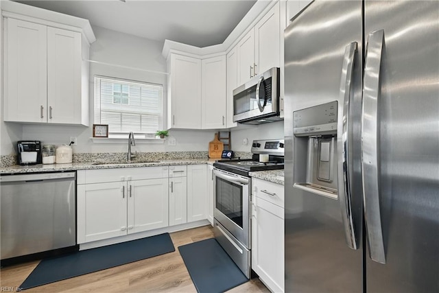 321 Pinner St, Suffolk, VA 23434 - kitchen featuring stainless steel appliances, white cabinets, light wood finished floors, and light stone countertops