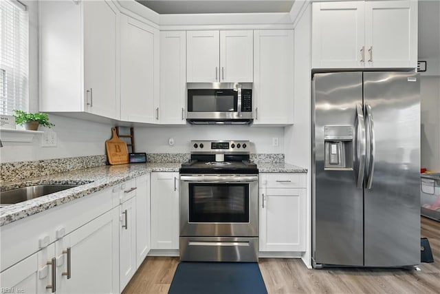 321 Pinner St, Suffolk, VA 23434 - kitchen with stainless steel appliances, light wood finished floors, white cabinetry, and light stone countertops