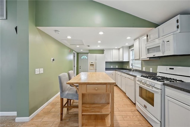 9001 Tidewater Dr, Norfolk, VA 23503 - kitchen with white appliances, open shelves, light wood-style floors, vaulted ceiling, and a center island