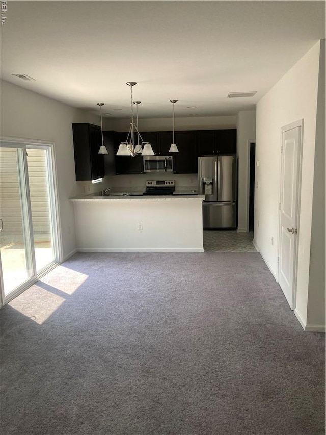 2801 Baldwin Dr, Chesapeake, VA 23321 - kitchen with stainless steel appliances, carpet flooring, decorative light fixtures, dark cabinetry, and a peninsula