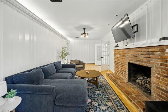 2400 Deerfield Cres, Chesapeake, VA 23321 - living room featuring wood finished floors, a ceiling fan, a brick fireplace, a baseboard heating unit, and french doors