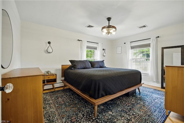 2400 Deerfield Cres, Chesapeake, VA 23321 - bedroom featuring multiple windows, a baseboard heating unit, and light wood-style flooring