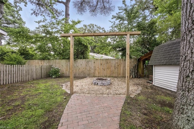 2400 Deerfield Cres, Chesapeake, VA 23321 - fenced backyard featuring an outdoor fire pit, a patio area, and an outbuilding