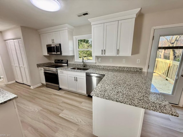 1046 Ivaloo St, Norfolk, VA 23513 - kitchen with appliances with stainless steel finishes, light wood finished floors, and white cabinets