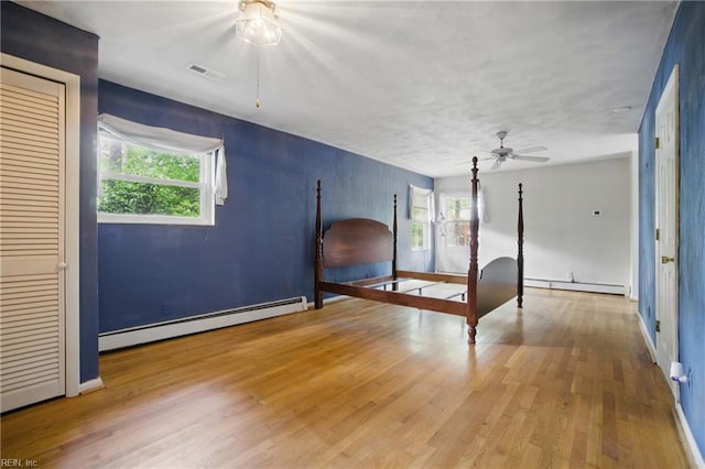 709 Wolfsnare Cres, Virginia Beach, VA 23454 - unfurnished bedroom featuring a baseboard radiator, multiple windows, wood finished floors, and a baseboard heating unit