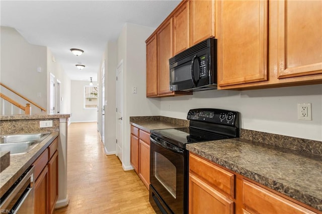 2741 Deep Creek Cmn, Chesapeake, VA 23323 - kitchen with black appliances, dark countertops, light wood-style floors, and brown cabinetry