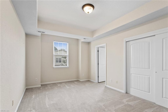 2741 Deep Creek Cmn, Chesapeake, VA 23323 - unfurnished bedroom featuring carpet floors, a closet, a tray ceiling, and a textured ceiling