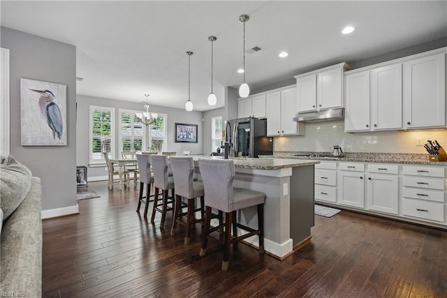 220 Wisdom Path, Chesapeake, VA 23322 - kitchen with refrigerator with ice dispenser, under cabinet range hood, dark wood-style floors, a center island with sink, and white cabinetry