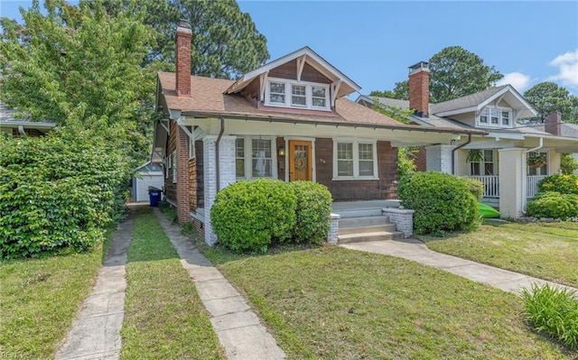 418 Massachusetts Ave, Norfolk, VA 23508 - bungalow featuring a chimney, covered porch, a front lawn, and brick siding