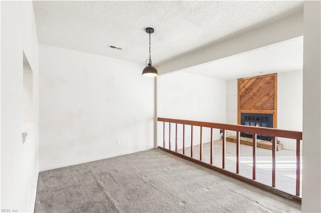 900 Monarch Dr, Virginia Beach, VA 23462 - spare room featuring carpet flooring, a warm lit fireplace, and a textured ceiling