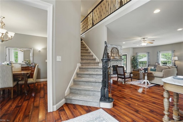 2316 Holland Rd, Virginia Beach, VA 23453 - stairway with a stone fireplace, wood-type flooring, a ceiling fan, a chandelier, and recessed lighting