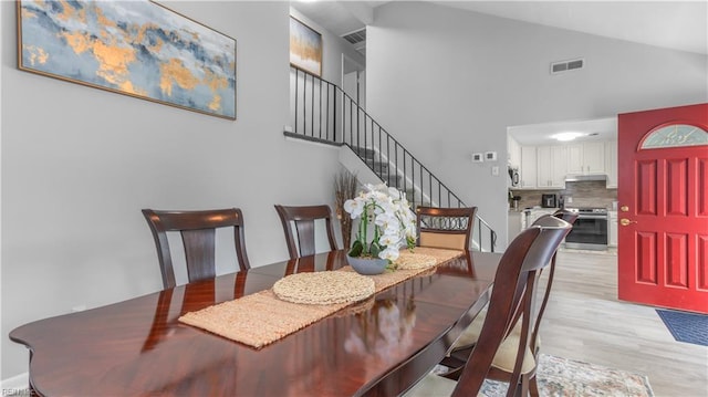 969 Sunnyside Dr, Virginia Beach, VA 23464 - dining room with high vaulted ceiling, light wood-style floors, and stairway