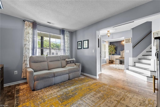 1205 Woods Way, Chesapeake, VA 23323 - living room with a textured ceiling, wood finished floors, and stairway