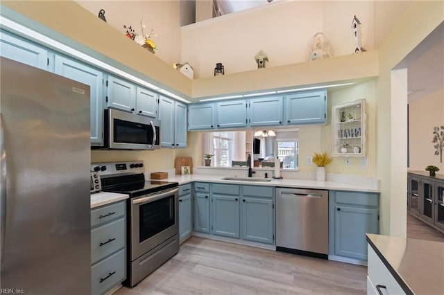 1013 Winged Foot Ct Unit A, Chesapeake, VA 23320 - kitchen featuring stainless steel appliances, blue cabinetry, light countertops, and light wood-type flooring