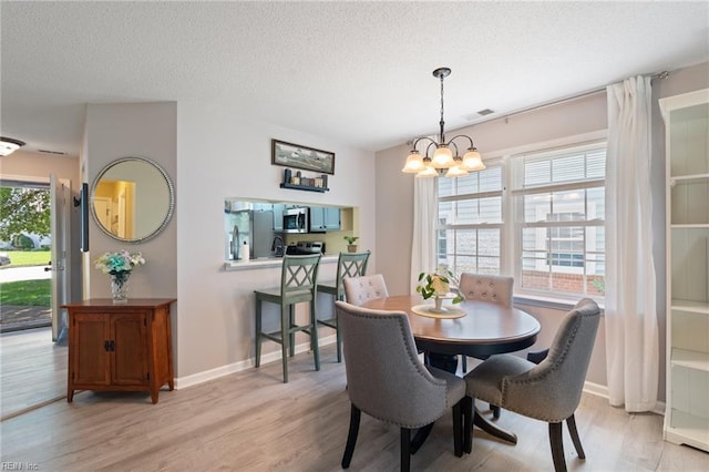 1013 Winged Foot Ct Unit A, Chesapeake, VA 23320 - dining room with a chandelier, light wood-style flooring, and a textured ceiling
