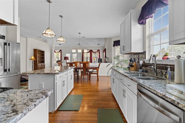2000 Kelsey Bay Ct, Chesapeake, VA 23323 - kitchen with stainless steel appliances, light wood finished floors, a kitchen island, backsplash, and white cabinetry