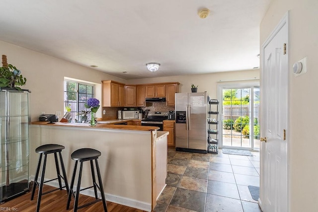 5537 Port Royal Dr, Virginia Beach, VA 23462 - kitchen featuring appliances with stainless steel finishes, under cabinet range hood, decorative backsplash, and healthy amount of natural light