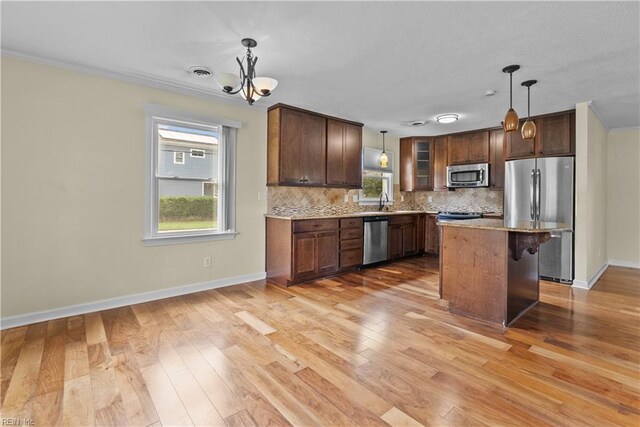 731 Carolina Ave, Virginia Beach, VA 23451 - kitchen with appliances with stainless steel finishes, tasteful backsplash, light wood finished floors, plenty of natural light, and crown molding