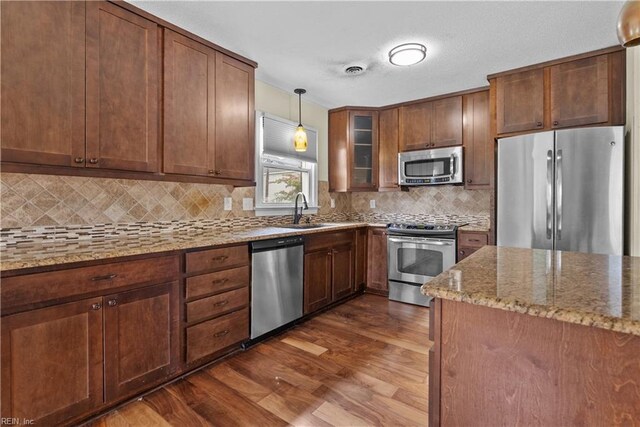 731 Carolina Ave, Virginia Beach, VA 23451 - kitchen with appliances with stainless steel finishes, dark wood-style floors, light stone counters, decorative light fixtures, and backsplash