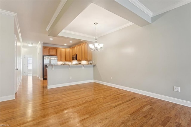 6885 Colemans Crossing Ave, Hayes, VA 23072 - kitchen featuring appliances with stainless steel finishes, a chandelier, a peninsula, crown molding, and a kitchen bar