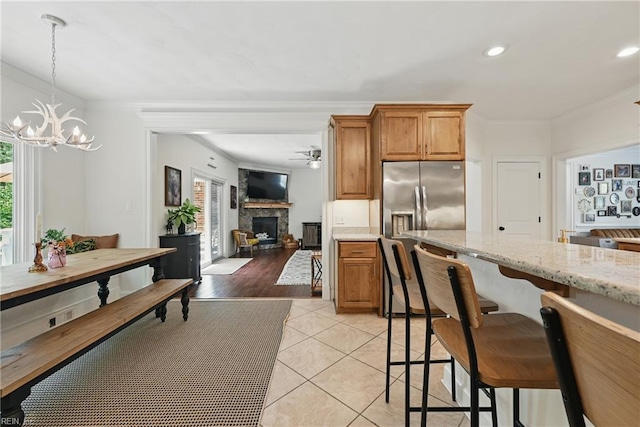 409 Torre Pine Ct, Chesapeake, VA 23322 - kitchen with a stone fireplace, ceiling fan, stainless steel fridge with ice dispenser, a chandelier, and ornamental molding